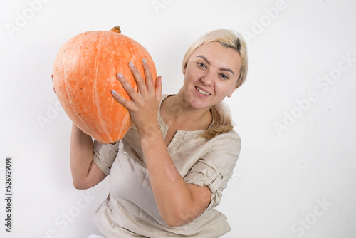 Portrait of beautiful young blonde woman with pumpkin ready for halloween celebration, mockup for postcard and invitation or advertisement