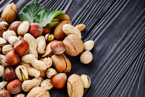 set of different nuts on a black rustic wooden background