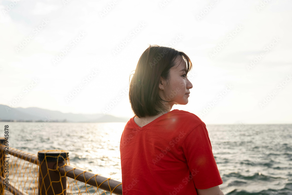 夕暮れの海にいる女性
