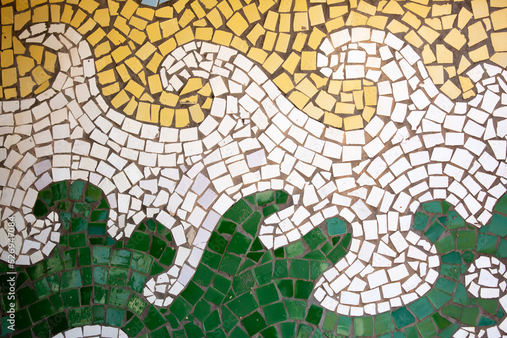 Obraz premium Detail of a beautiful abstract decoration of a building decorated with wave-shaped ceramic mosaics. Venetian mosaic as a decorative background. Mosaic ceramic stones for decorating pool walls.