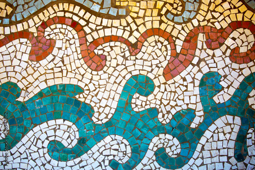 Detail of a beautiful abstract decoration of a building decorated with wave-shaped ceramic mosaics. Venetian mosaic as a decorative background. Mosaic ceramic stones for decorating pool walls.