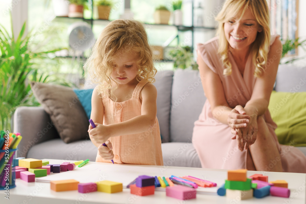Girl and mother drawing together at home Girl and mother drawing together at home