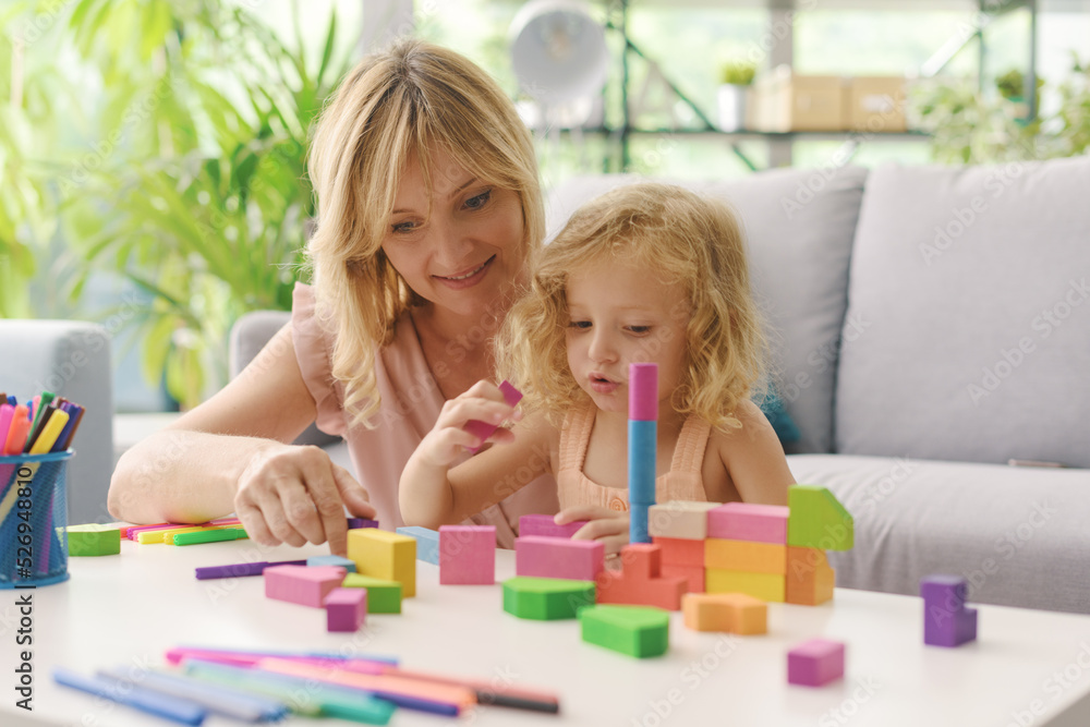 Happy woman playing with her daughter at home Happy woman playing with her daughter at home