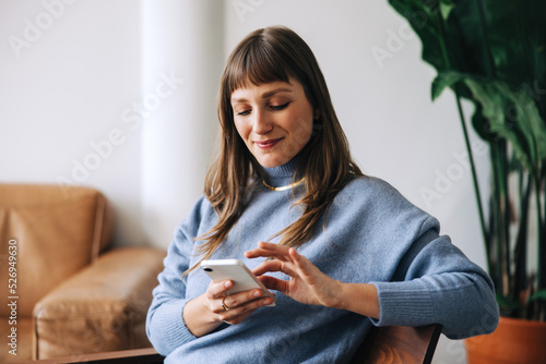 Businesswoman using a mobile phone in an office lobby photo