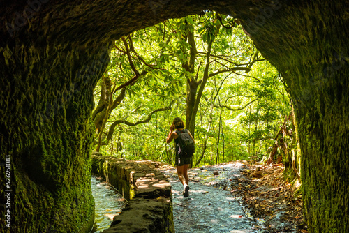A young woman trekking in the cave at Levada do Caldeirao Verde, Queimadas, Madeira photo