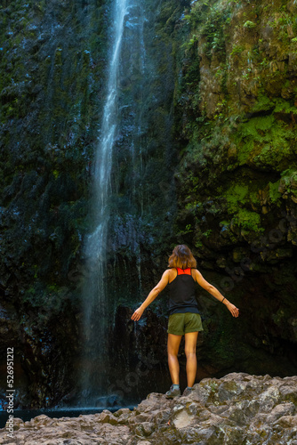 A young woman at the impressive waterfall at the Levada do Caldeirao Verde  Queimadas  Madeira