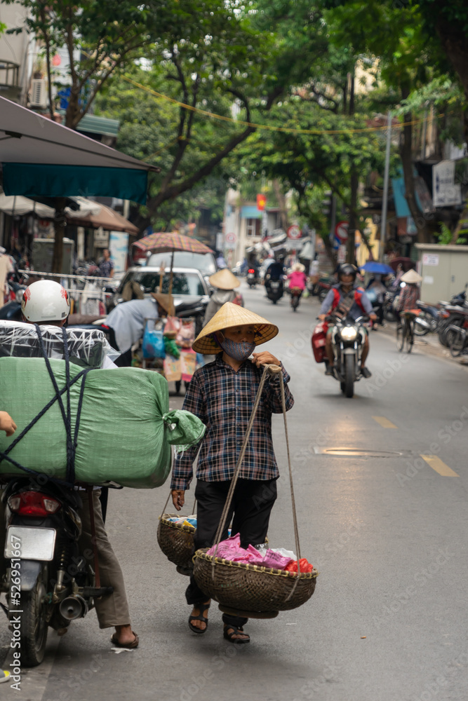 Naklejka premium Vietnamese woman selling fruit and vegetables on the street. Traditional sale. Hanoi