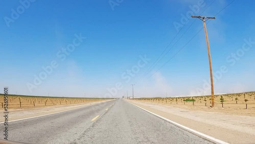 Driving along drought-stricken vineyards near Fresno, California on a hot, sunny day