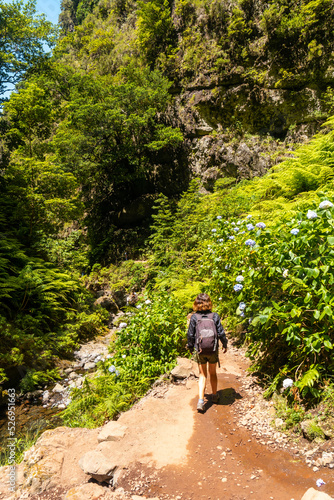 A young woman on the trail next to the waterfall at Levada do Caldeirao Verde, Queimadas, Madeira © unai