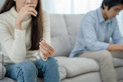 Divorce. Woman taking off wedding ring. Asian couples are desperate and disappointed after marriage. Husband and wife are sad  upset after quarrels. distrust  love problems  betrayals. family problem