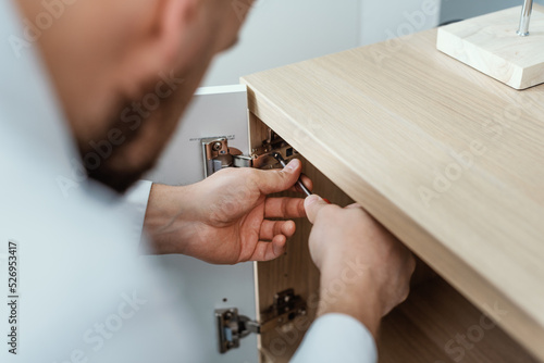 Man repairing a cabinet door hinge photo