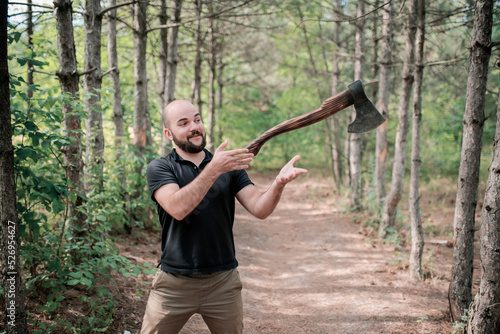 A bearded man throws an axe. The axe hovers in the air