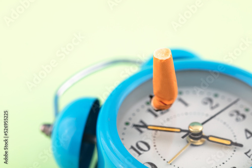 Cigarette butt on alarm clock quit smoking time