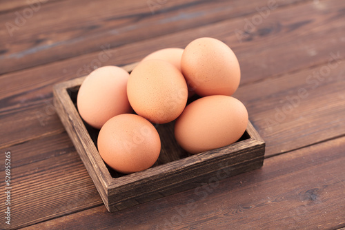 Wooden box with several eggs on the table