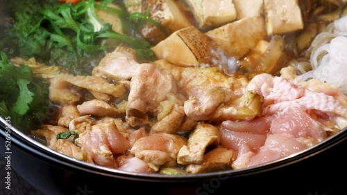 ぐつぐつと沸騰し、食欲をそそる湯気が立ち上る「地鶏のすき焼き」。弾力ある地鶏の質感と新鮮な野菜の色彩が際立つ動画素材は、冬の宴会メニューや、本格的な鍋料理を紹介する販促広告に最適な高品質素材です。 | Steaming hot Sukiyaki with premium local chicken and vegetables.