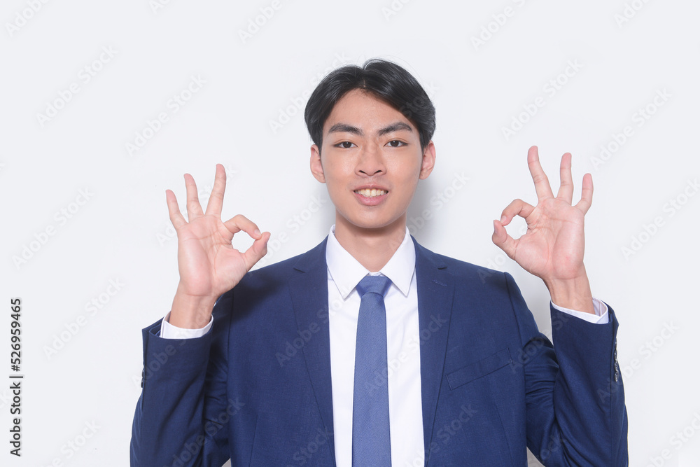 young businessman wearing suit, blue shirt with tie with ok gesture standing in studio young businessman wearing suit, blue shirt with tie with ok gesture standing in studio