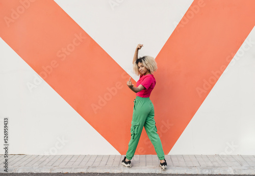 Young woman making obscene hand gesture on footpath
