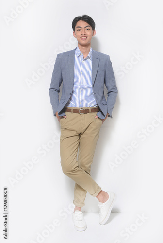 Full body young businessman wearing gray suit,striped shirt with khaki pants, standing in studio photo