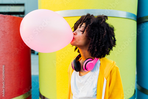 Young woman with eyes closed blowing bubble gum photo