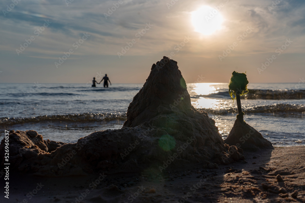 Sand castle on the beach, summer sunset