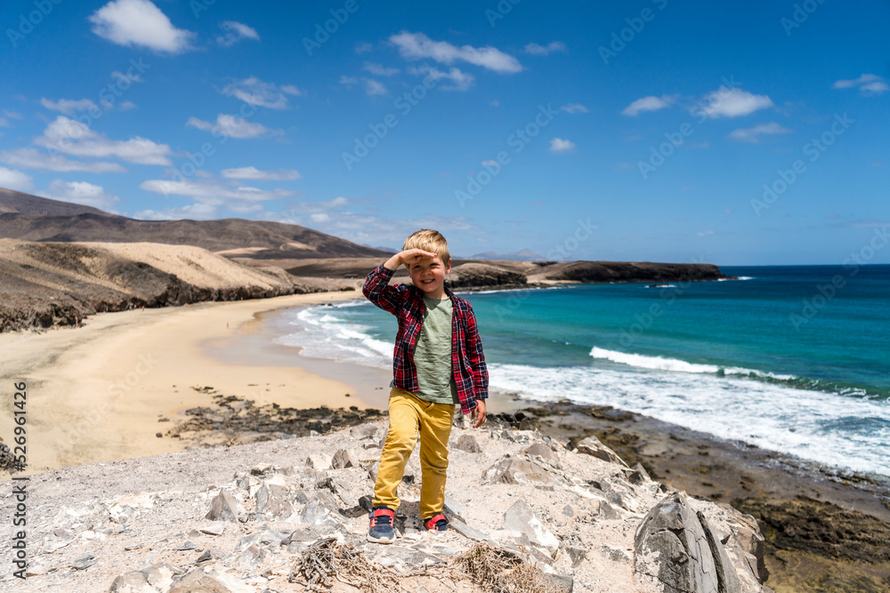 Naklejka premium Small boy enjoying at beach called Caleta del Congrio in Los Ajaches National Park at Lanzarote, Canary Islands, Spain