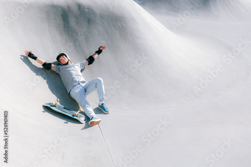 Man with skateboard resting in skatepark photo