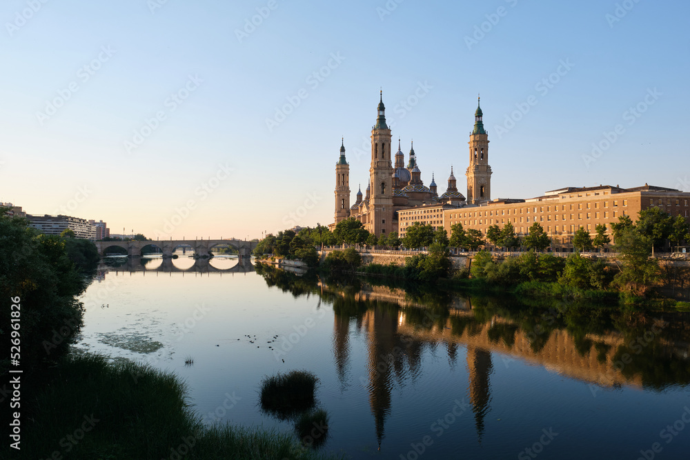 Basilica of Our Lady of the Pillar and Ebro river at sunrise in Zaragoza, Spain. El Pilar de Zaragoza. Basilica of Our Lady of the Pillar and Ebro river at sunrise in Zaragoza, Spain. El Pilar de Zaragoza.