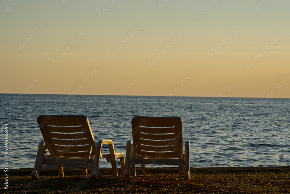 Empty sun loungers with ocean view