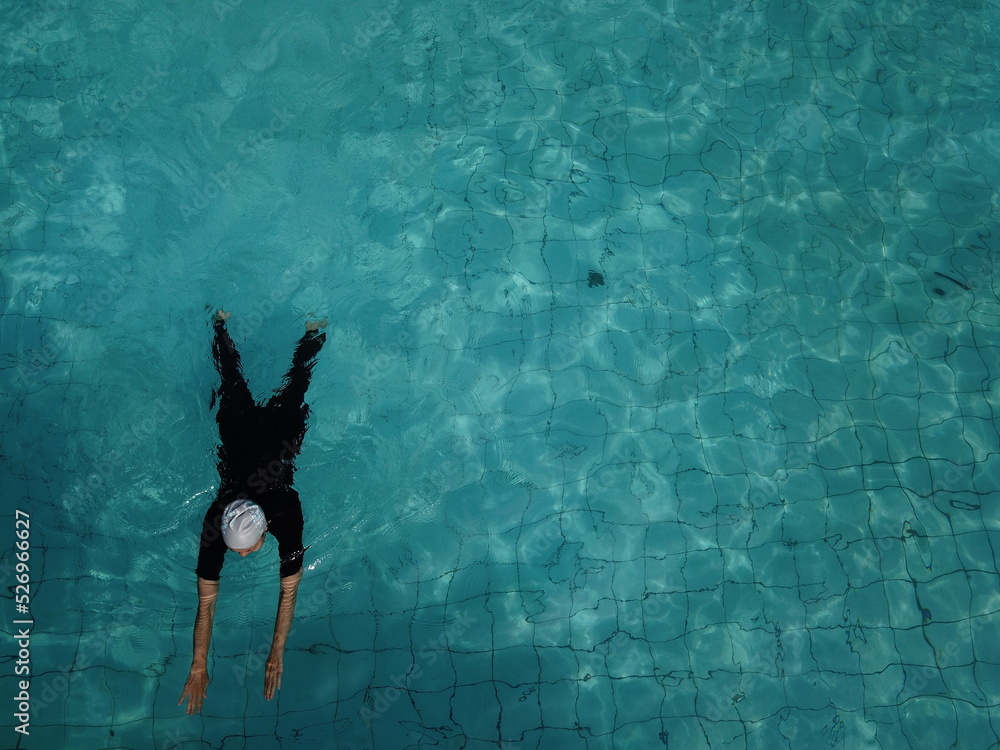 drone view of a person swimming in the pool