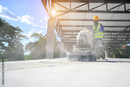 Male construction workers use a finishing and finishing machine or factory epoxy concrete for plastering and polishing concrete floors.