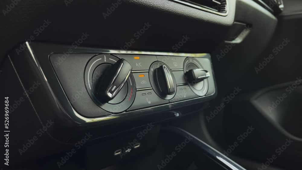 Turning on air conditioner and fan, closeup of hand and finger, car interior Turning on air conditioner and fan, closeup of hand and finger, car interior