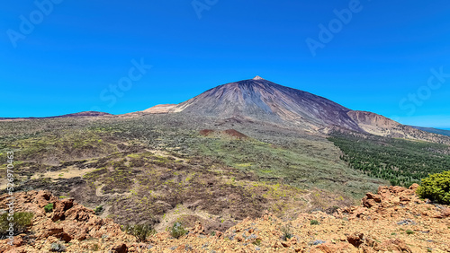 Scenic view on volcano Pico del Teide seen from Riscos de la Fortaleza, Mount El Teide National Park, Tenerife, Canary Islands, Spain, Europe. Hike via La Canada de los Guancheros dry desert plain