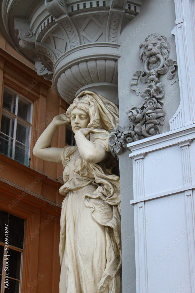 Beautiful woman figure statue, the facade of a historical building in the old town of Vienna, Austria, Central Europe. Detailed stone sculpture, exterior view of downtown houses.