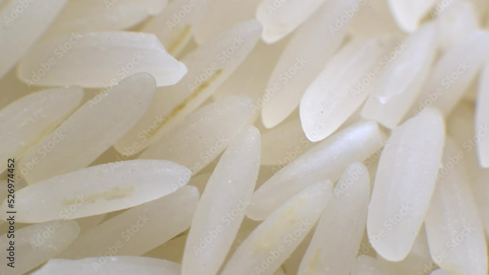 White long polished rice close-up in macro mode rotates in a circle. Selective focus White long polished rice close-up in macro mode rotates in a circle. Selective focus