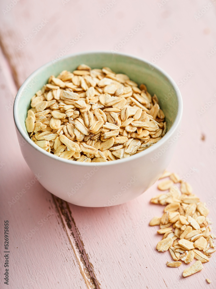 White bowl of oat on a pink background White bowl of oat on a pink background