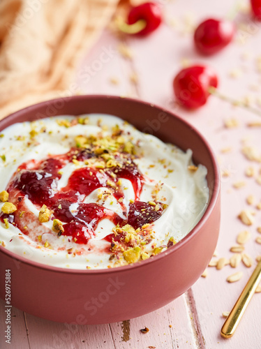 Bowl of yogurt served with cherry jam and peanuts