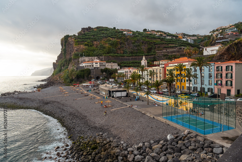 Aerial view of Ponta do Sol Beach in the east of Madeira in summer, palm trees and colored houses
