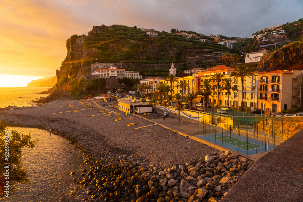 Orange sunset in Ponta do Sol, Madeira, aerial view of the beach in summer. Portugal