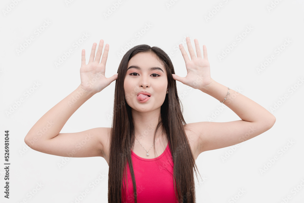 A mischievous and bratty female teenager teases someone, sticker her tongue  out and taunting with her hands. Stock Photo | Adobe Stock