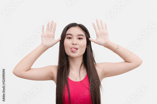 Photography A mischievous and bratty female teenager teases someone, sticker her tongue out and taunting with her hands