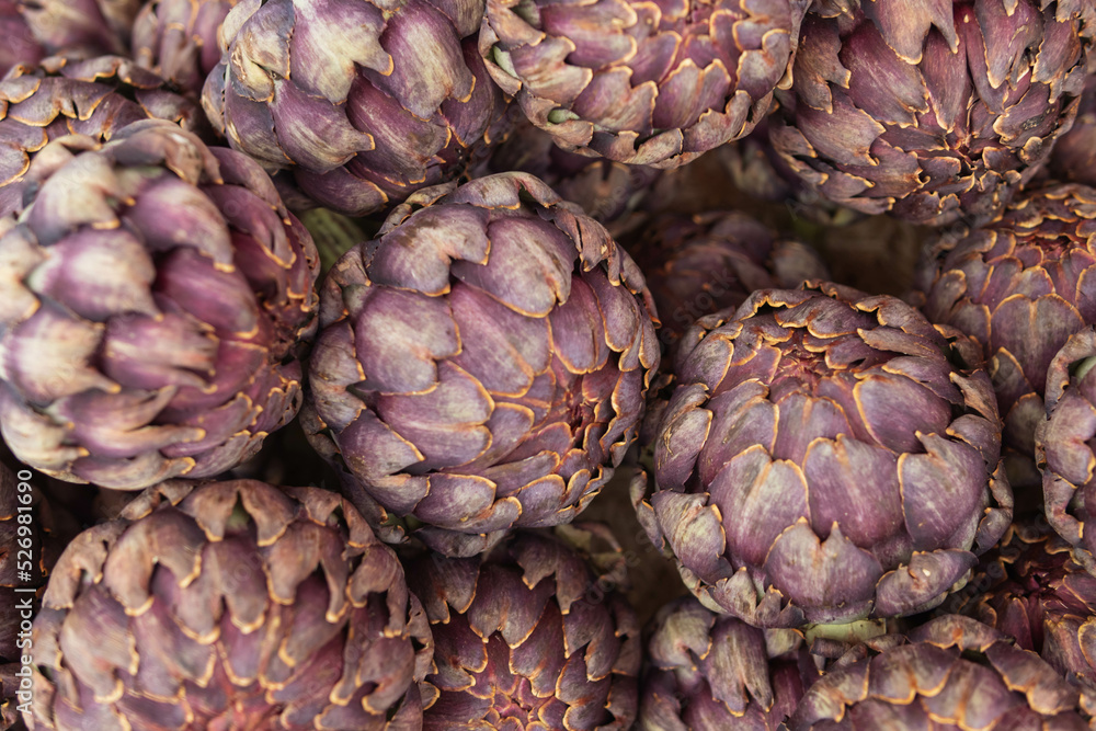 a lot of artichokes close-up. Artichokes are sold on a showcase, healthy food. a lot of artichokes close-up. Artichokes are sold on a showcase, healthy food.