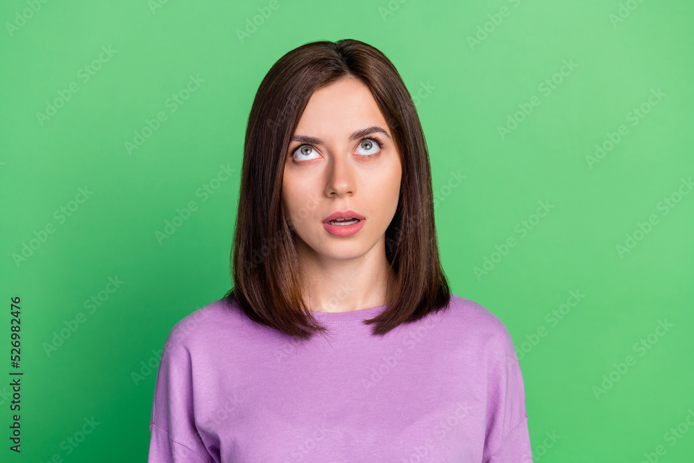 Obraz premium Closeup photo of young attractive woman looking up interested information speechless isolated on green color background