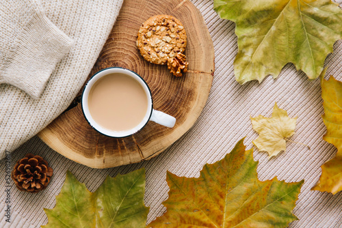 Autumn mood: cup of coffee, warm wool sweater and yellow leaves. Seasonal breakfast, morning coffee. The concept of home comfort and cozy atmosphere. © Katerina Bond