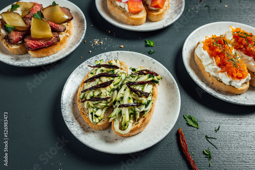 Fresh and helthy different kinds of colorful sandwiches on dark blue background  restaurant food  Party starter or appetizer - flat lay composition.