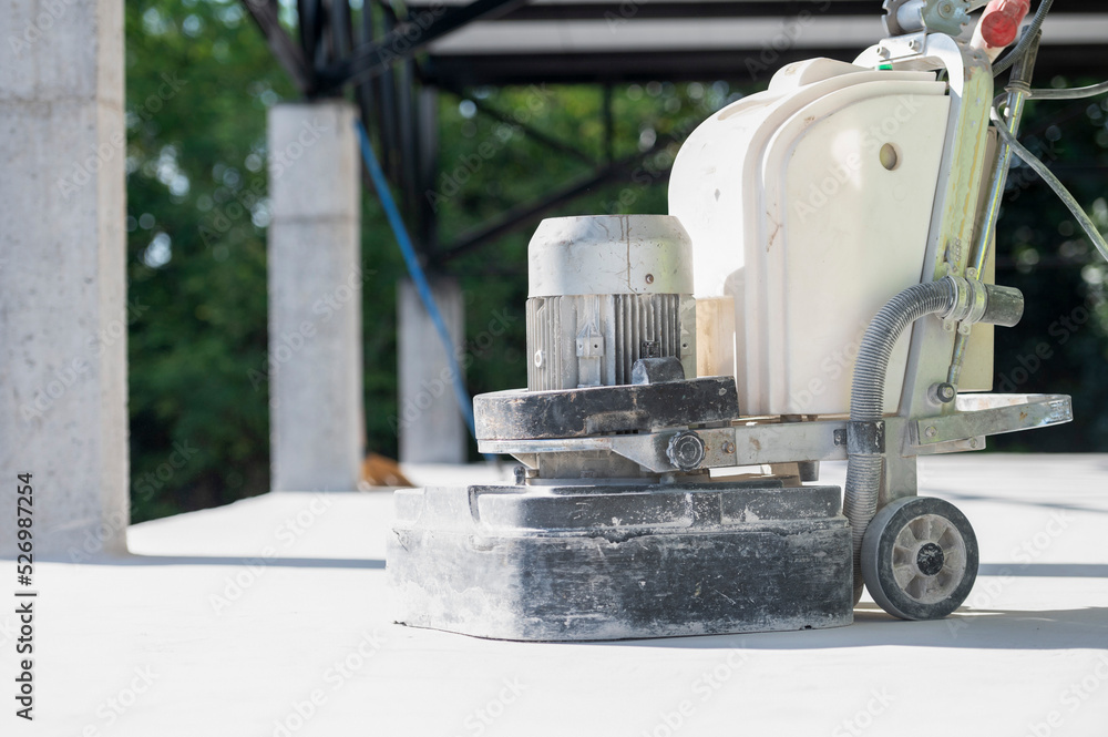Construction workers use a machine to polish and finish surfaces or epoxy concrete on the home site. Construction workers use a machine to polish and finish surfaces or epoxy concrete on the home site.