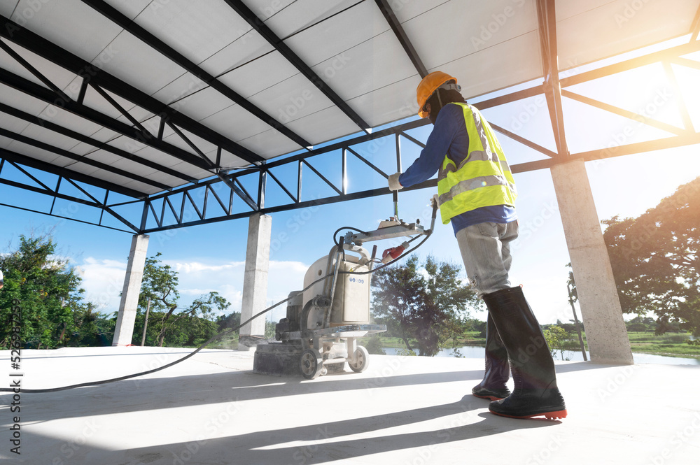 Construction workers use a machine to polish and finish surfaces or epoxy concrete on the home site. Construction workers use a machine to polish and finish surfaces or epoxy concrete on the home site.