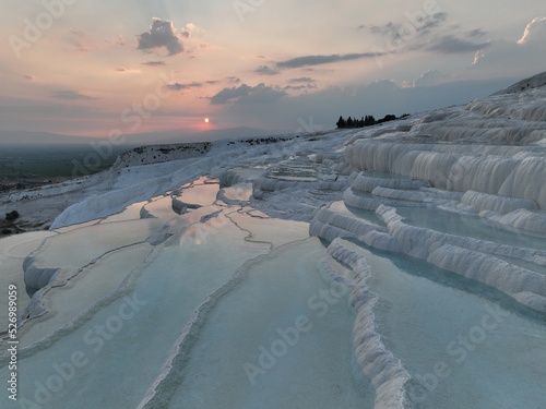Pamukkale Travertines Cinematic Aerial Drone footage. Turkish famous white thermal bath with healthy clean water in a beautiful sunset. 
