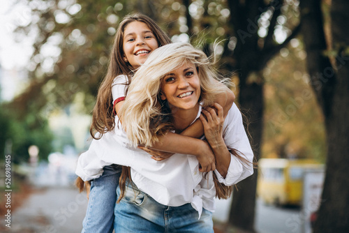 Mother with daughter together in autumn park