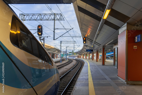 High-speed train on the railway platform in the early morning, passengers are waiting to board the train cars, railway background, rail travel, railway in Krakow. Copy space