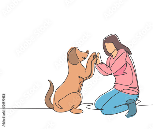 One line drawing of young happy woman squat then giving high five gesture to his dog at outfield park as friendship symbol. Pet care concept. Modern continuous line draw design vector illustration